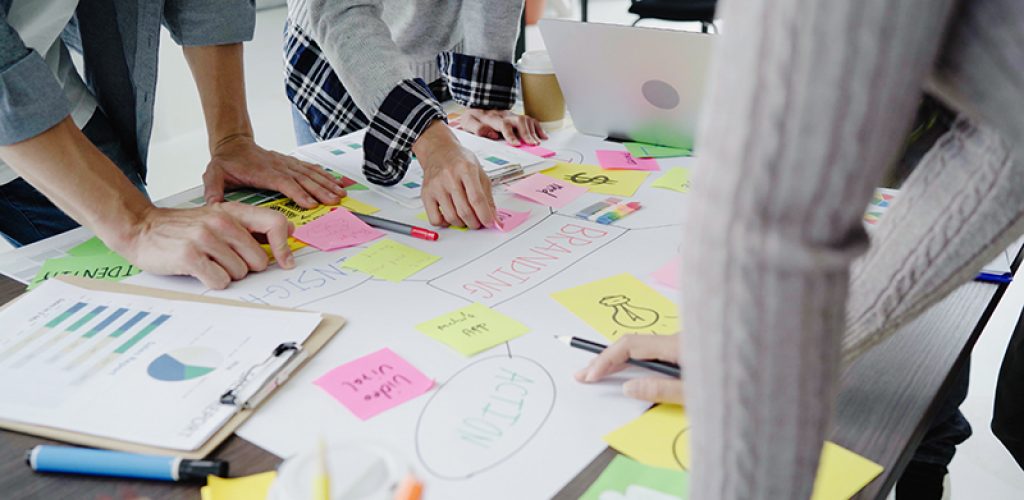 Group of casually dressed business people discussing ideas in the office. Creative professionals gathered at the meeting table for discuss the important issues of the new successful startup project.